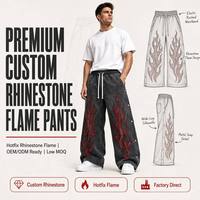 Pantalon de survêtement streetwear personnalisé avec logo, effet délavé, coupe oversize, strass, jambes évasées et superposées, imprimé flamme et broderie