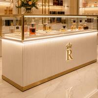 Comptoir de présentation de parfums de luxe avec finition dorée et vitrine en verre pour boutique de parfums