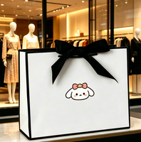 Sac en papier cadeau blanc de luxe recyclable en gros d'usine avec nœud en ruban noir et logo personnalisé pour l'emballage de vêtements et d'artisanat de détail