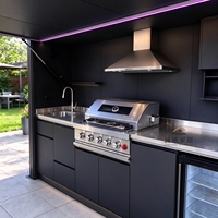 Cuisine extérieure sur mesure avec barbecue, évier, comptoir de service et réfrigérateur à porte vitrée