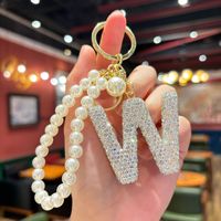 Vente en gros de porte-clés en strass avec 26 lettres, charme en cristal alphabet avec chaîne de perles pour femmes