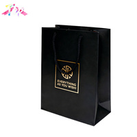 Sac en papier noir de luxe avec logo personnalisé, poignées en ruban doré, emballage écologique pour bijoux, cosmétiques et vêtements