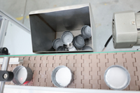 Ligne d'emballage automatique pour le posement de joints d'étanchéité sur les couvercles de bouteilles en verre et en plastique