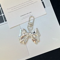 KR006 Porte-clés en métal avec fermoir mousqueton, pendentif nœud métallique brillant, breloque minimaliste et tendance pour sac à dos, pour filles au quotidien
