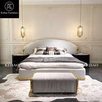 Lit capitonné de luxe avec tête de lit incurvée, taille King Size, en velours moderne avec accents métalliques dorés pour chambre principale de villa