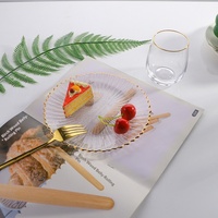 Assiette de présentation moderne et minimaliste en verre transparent avec bordure dorée cannelée, idéale pour les fruits, pour table de salle à manger, événements et fêtes