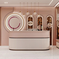Comptoir de réception moderne rose pour salon de beauté avec mur d'accentuation circulaire LED, niches d'exposition personnalisées pour boutique, design complet