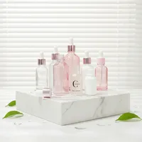 Flacons cosmétiques vides en verre cylindrique rose doré de 30 ml et rose translucide de 50 ml avec impression sérigraphique