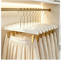 Cintres en bois noir et blanc pour pantalons et jupes avec pinces métalliques dorées réglables pour jeans, pantalons et présentation en armoire