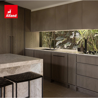 Meuble de cuisine Alland au design moderne, texture chêne mat, lignes épurées, avec îlot de cuisine en pierre chaude effet cascade pour la rénovation résidentielle