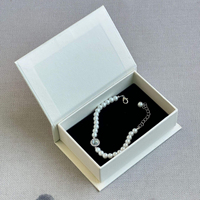 Boîte à bijoux rigide beige en forme de livre avec fermeture magnétique pour la personnalisation de colliers de luxe et la vente au détail professionnelle en boutique