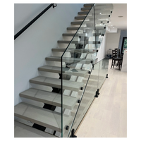 Escalier monopoutre en acier découpé au laser avec marches en noyer et balustrade continue en verre, style minimaliste