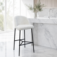 Tabouret de bar en bouclette blanc crème, rembourré, avec pieds coniques en métal noir et repose-pieds en forme de H pour comptoir de bar