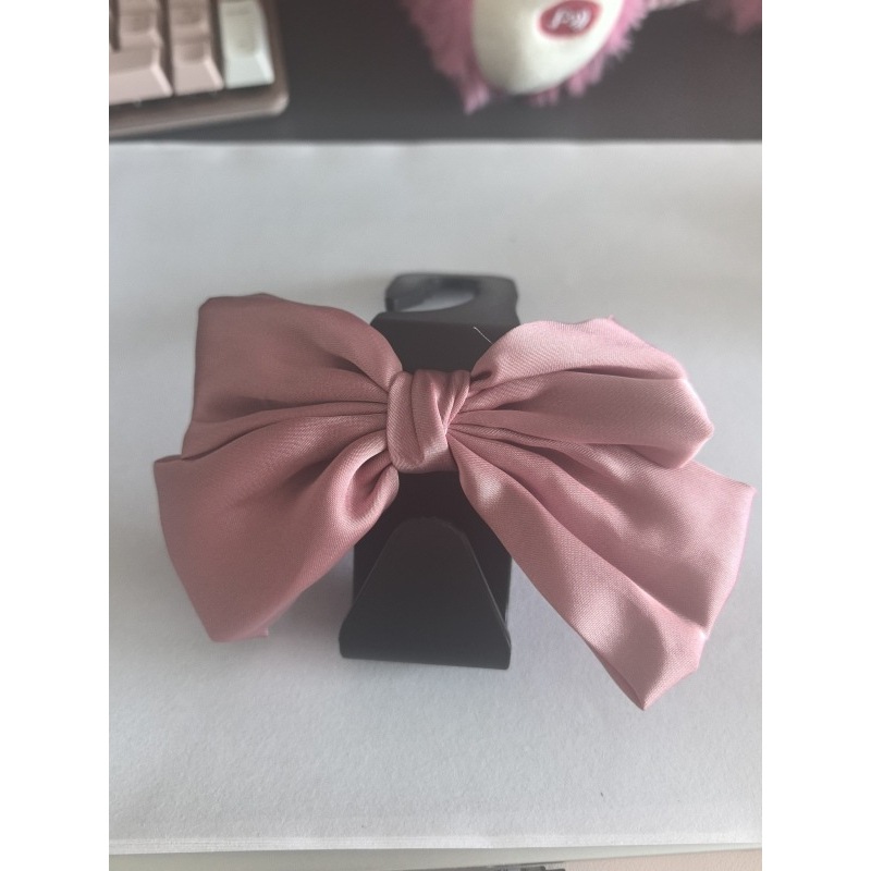 Crochet noir en forme de 7 avec nœud rose attaché