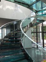 Escalier courbé pour loft, design gain de place avec marche simple et main courante.