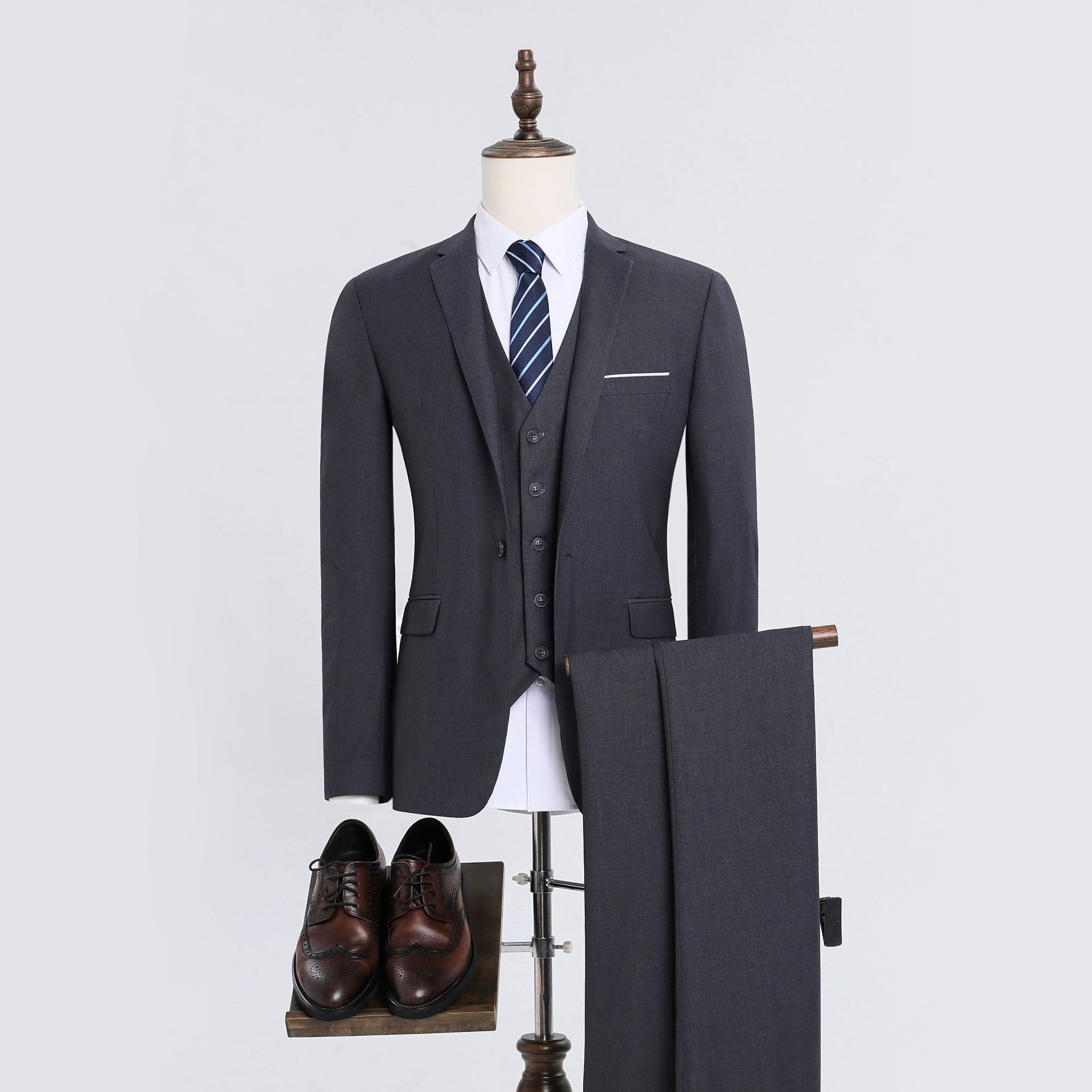 Chaqueta gris de un botón, chaleco y pantalón.