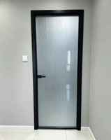Porte de salle de bain minimaliste standard à charnières avec cadre en alliage titane-magnésium et panneaux en verre dépoli pour toilettes intérieures d'hôtel
