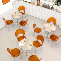 Moderne Kaffeehaus-Tische und -Stühle, ein Runder Edelstahltisch und Transparente Acrylstühle