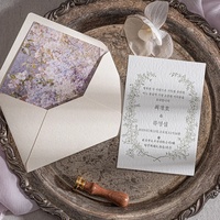 Invitation de mariage personnalisée en papier fait main à bords festonnés, avec ruban blanc et sceau de cire doré, imprimée en typographie