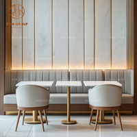 Ensemble de mobilier de restaurant avec dessus de table en marbre et bases en métal doré, chaises en cuir gris à dossier haut et canapé banquette