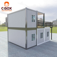 Maison conteneur préfabriquée Cbox à deux étages avec mur-rideau en verre, escalier extérieur en acier et terrasse sur le toit
