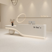 Bureau de réception moderne personnalisé à ondulations douces avec base sphérique unique pour clinique cosmétique, salon de manucure, spa de beauté
