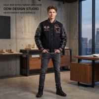 Blouson universitaire personnalisé OEM en cuir noir épais pour homme, avec broderie de haches croisées de luxe, style streetwear, type bomber