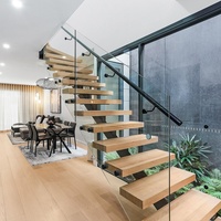Escalier moderne en bois massif avec poutre monobloc en acier inoxydable et garde-corps en verre, écologique et durable pour villa intérieure