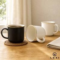 Mug à café en céramique noir mat avec bordure dorée et lettrage imprimé, corps large et rond, poignée en forme de C, idéal pour le bureau au quotidien