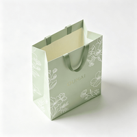 Sac shopping en papier personnalisé avec logo imprimé botanique et poignée en ruban pour emballage cadeau de marque de soins de beauté bio et spa