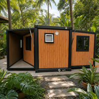 Maison conteneur pliable extensible en grain de bois teinté avec cadre et fenêtres noirs pour le glamping et l'hébergement en jardin