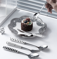 Ensemble de couverts en acier inoxydable à motif blanc et noir, avec poignées en céramique, pour une table de cuisine lumineuse et coordonnée