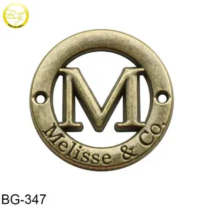 圆形空心标签设计古董黄铜M字母压花衣服的金属标签标志