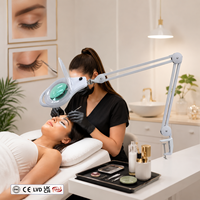 Lampe loupe à lentille optique en forme de goutte d'eau, avec double articulation métallique, bras cantilever à bascule latérale et écran anti-poussière monobloc