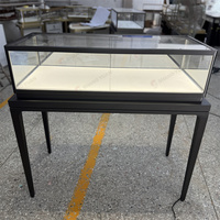 Vitrine à bijoux autoportante en verre avec cadre noir, pieds hauts et éclairage LED pour les bijouteries professionnelles