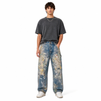 Jean en denim bleu avec empiècements patchwork clairs sur le devant, détails de poches effet éclaboussures multicolores et ourlets bruts usés