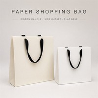 Sacs shopping personnalisés en papier kraft blanc avec poignée en ruban noir, soufflets latéraux et fond plat – Sacs promotionnels style Instagram pour la vente au détail