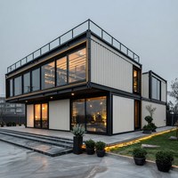 Maison conteneur préfabriquée compacte avec façade moderne, terrasse et aménagement jardiné