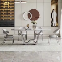 Table à manger de luxe avec plateau en pierre, base profilée et pieds incurvés au design créatif pour mobilier de salle à manger