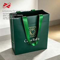 Sac en papier vert forêt personnalisé avec poignée en ruban satiné et emblème en feuille d'aluminium pour la vente de produits de luxe