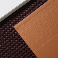 Invitation de mariage traditionnelle en couverture rigide marron café avec bordure gaufrée et monogramme en acrylique doré pour mariage culturel