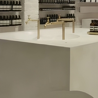 Comptoir d'exposition cosmétique GZowin avec éclairage LED et finitions en laiton, microciment personnalisable pour les magasins de détail de luxe
