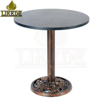 Table ronde en fonte avec finition cuivre vintage, base sur pied robuste avec plateau en mélamine pour café, bar, restaurant