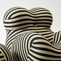 Fauteuil de salon sculptural en mousse moulée monobloc, design enveloppant, avec ottoman en tissu rayé