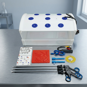 Simulador de entrenamiento laparoscópico rectangular con pinzas, tijeras y accesorios para práctica quirúrgica. - Product Image 1