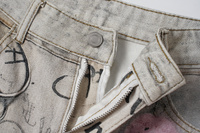 Jean baggy unisexe beige gris délavé avec imprimé graffiti intégral, coupe large, avec breloques en peluche et détails de chaînes colorées