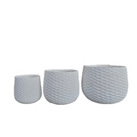 Jardinières modernes en résine texturée blanche avec motif circulaire pour plantes vertes d'intérieur, style minimaliste.