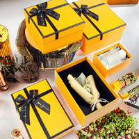 Boîte d'emballage cadeau en carton magnétique avec logo personnalisé orange avec nœud ruban bouquets de fleurs pour bougie spécifications de feuille de cadeau