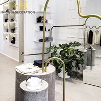 Présentoir mural rotatif pour vêtements d'enfants, mobilier de vitrine pour boutique de vêtements minimalistes à courbes ondulées