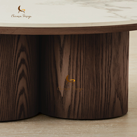 Table basse Zen Wabi Sabi avec base en chêne fumé patiné, pieds cylindriques épais, forme ronde organique et plateau en marbre apaisant